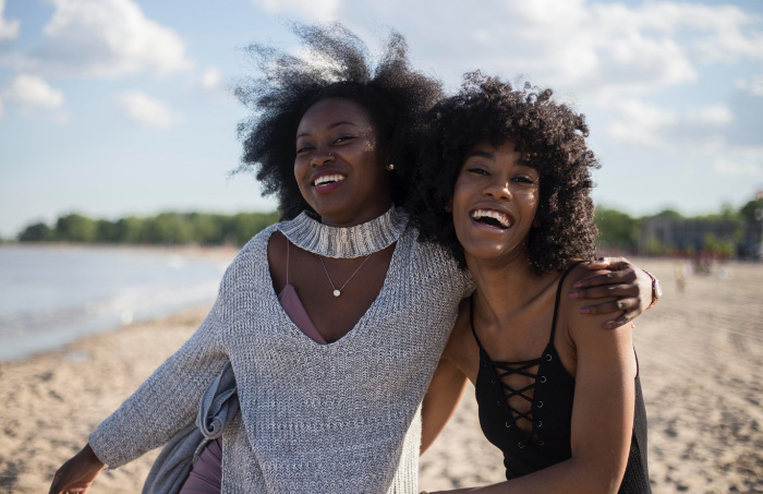 two women smiling on a beach