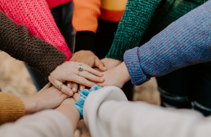 people placing hands on top of one another